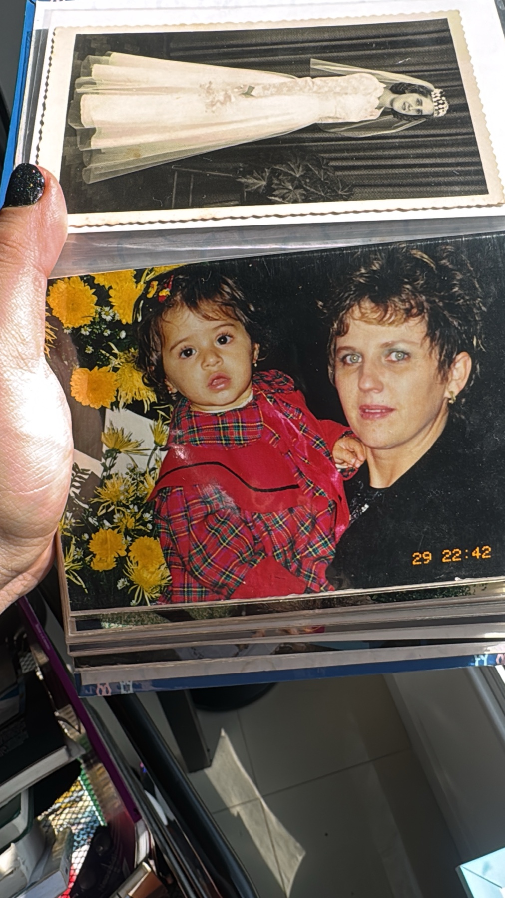 Fotografia antiga de Ana criança no colo de Suzane Beatriz Vanzin, em um álbum de família